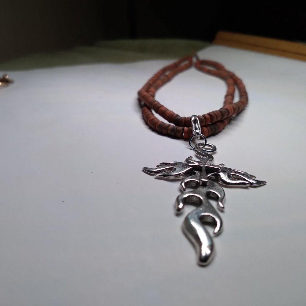The silver tone cross and red puka shells 16 inch